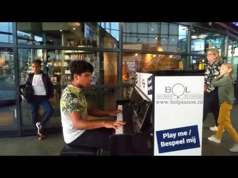Tyrell George bespeelt de piano op station Amsterdam Sloterdijk