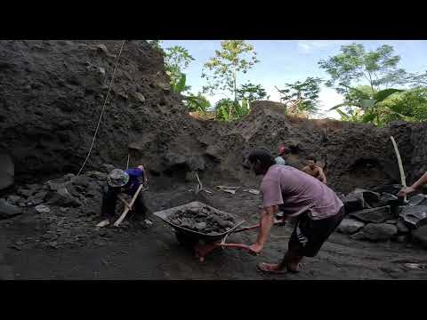 Dig up the black sand around the big rocks, before the dump truck comes