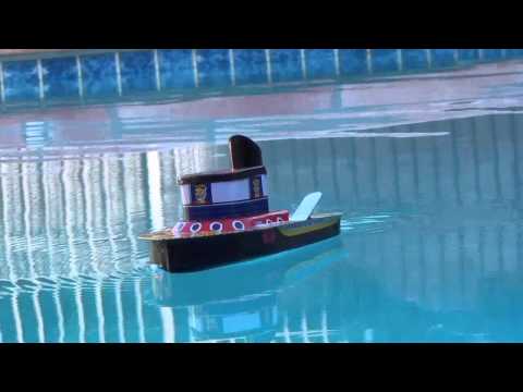 Dad relives childhood with tin steamboat.