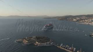 D-Log M. Kusadasi, Turkey. Virgin Voyages Resilient Lady cruise ship maneuvers in the bay at suns...
