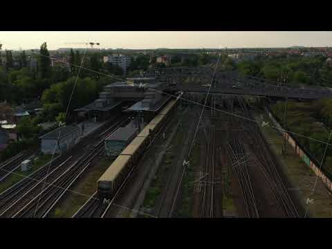 Aerial view of S bahn train arriving into station under Bosebrucke bridge. City scene in evening