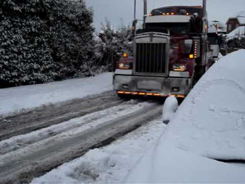 big rig truck pulls 18 wheeler uphill in snow