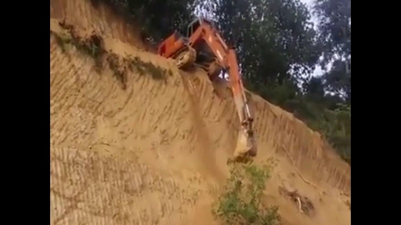 escavadeira descendo o  morro na vesrtical
