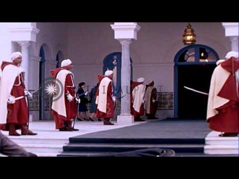 Palace guards hold swords lined up on both sides of carpet leading to entrance of...HD Stock Footage