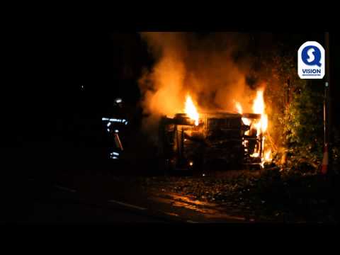 Auto op zijn kant en in lichterlaaie