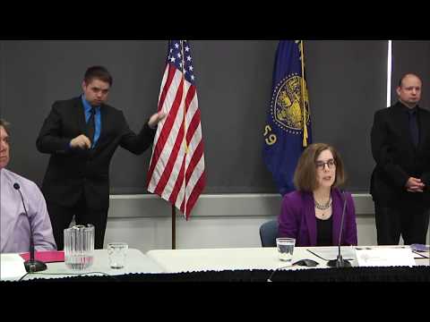 Governor Kate Brown presenting at the June 12th press conference with two sign language interpretors in the background