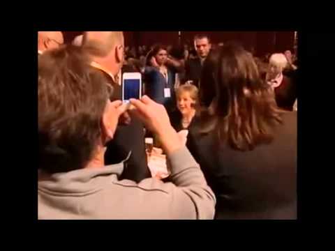 Camarero tira cervezas en cuello de Angela Merkel