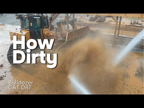 It's very dirty. Washing the CAT D8T bulldozer heavy equipment.