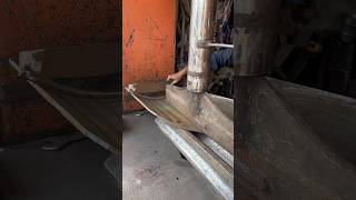 A heavy metal plate is being bent to the required size using a hydraulic press.