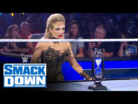 Scarlett places an hourglass in front of Roman Reigns