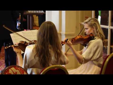 Holly Bowling and Josephine Lloyd playing violin duets at a wedding in Surrey