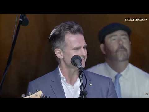 Vigil attendees sing an emotional Waltzing Matilda