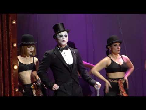 Ο Τάκης Ζαχαράτος ως κομπέρ στο μιούζικαλ Cabaret [Καμπαρέ] σε σκηνοθεσία Σωτήρη Χατζάκη (Θέατρο Παλλάς, 2018). Με την ειρωνική του παρουσία, ο κομπέρ σχολιάζει τη δράση και συνδέει τα νούμερα του Kit Kat Klub με την πολιτική κατάρρευση της Δημοκρατίας της Βαϊμάρης.