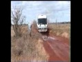Tour Coach On The Muddy Gunbarrel Highway In Outback Australia