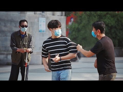 當目睹有人騙盲人的錢，有人一把拽住了他