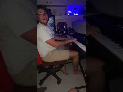 Guy Plays Piano And Harmonica As Friend Holds It