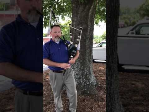 Russ Anderson plays bagpipes outside Inn on the Square