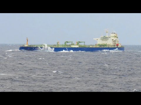 A tanker loaded to capacity with 100,000 tons is underway on the open sea.
