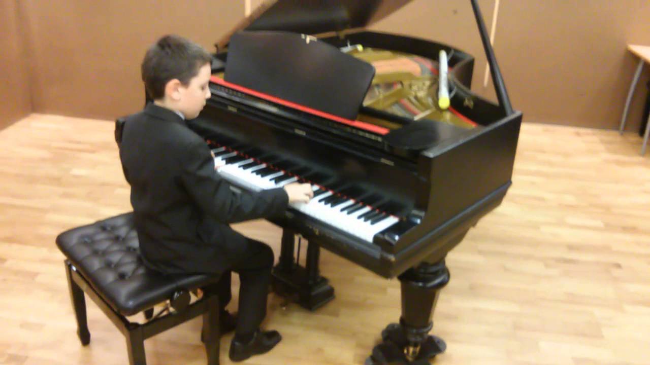 Szymon relaksujący się przy fortepianie po otrzymaniu 1 nagrody na Międzypowiatowym Przeglądzie Talentów w Środzie Wlkp. 2014