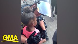 Police officer comforts little girl after she asks: 