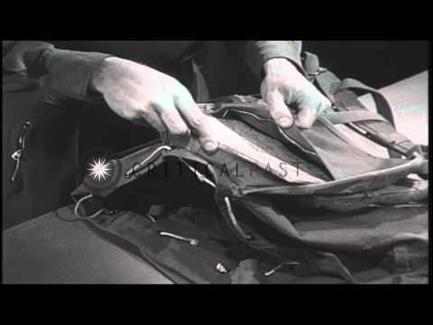 A ski trooper places skiing equipment inside a rucksack in an equipment room in t...HD Stock Footage