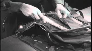 A ski trooper places skiing equipment inside a rucksack in an equipment room in t...HD Stock Footage