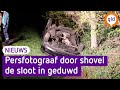 Persfotograaf met auto en al door shovel de sloot in geduwd. Beeld: Persbureau Heitink