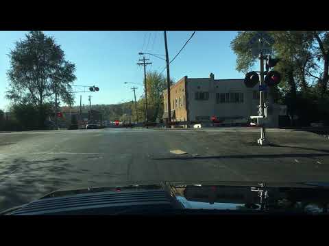 Car crosses tracks while train is coming and crossing arms are down and nearly collides