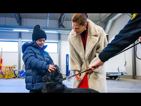 Princess Estelle and Prince Oscar cuddeling with a dog at the Swedish Customs office