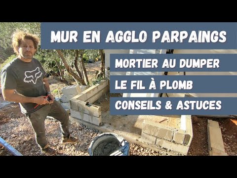 Montage mur en agglos ou parpaings et mortier gâché au dumper à chenilles