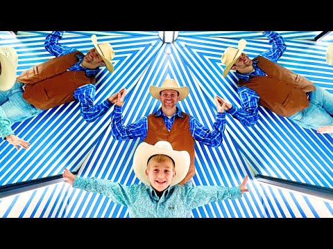 Group of five people dressed as cowboys with brown vests, blue shirts, and hats, standing under a blue-and-white striped canopy with arms outstretched.