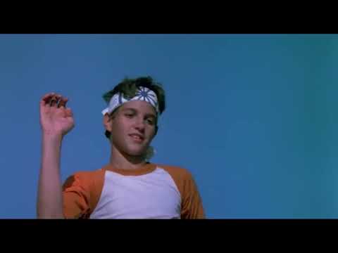 1984 The Karate Kid official trailer frame with Daniel practicing the crane kick at the beach