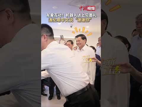 Friendly interaction! #ChineseRobot presents a gift to Thongloun! Thongloun says \Thank you\ in C...
