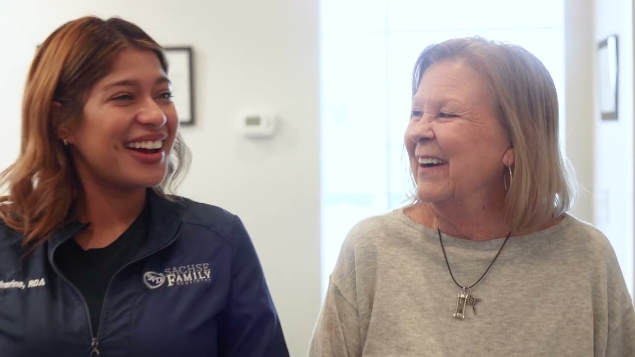 Dental team member laughing with a patient