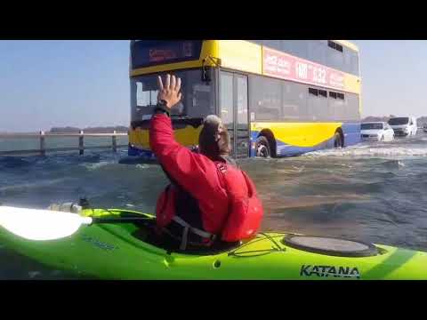 Man Kayaks Alongside Traffic on Flooded Road on Mersea Island, Essex