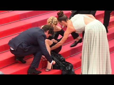 Cannes : Efira rattache ses chaussures, assise sur les marches | AFP Images