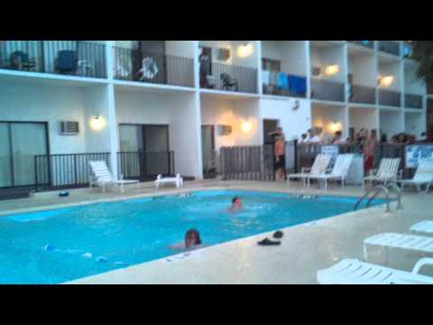 Guy jumping in pool from 4th floor hotel balcony