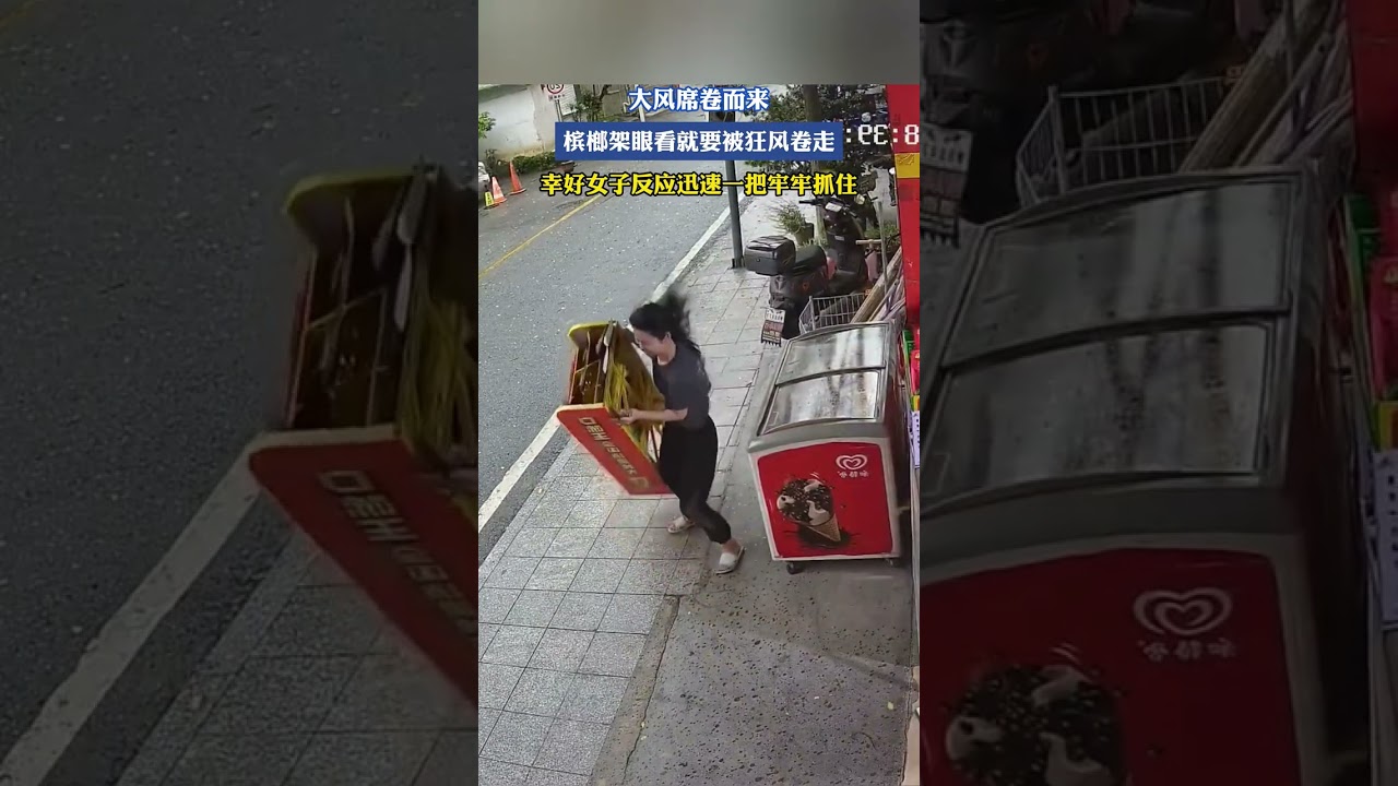 大风席卷而来，槟榔架眼看就要被狂风卷走，幸好女子反应迅速一把牢牢抓住