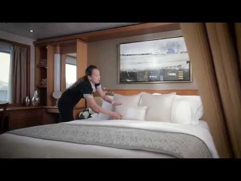 Housekeeping staff placing pillow on a bed