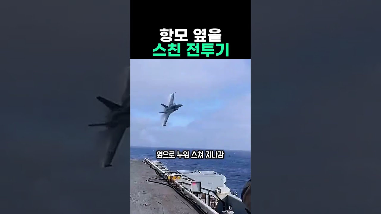 항공모함 옆을 지나는 전투기의 비행