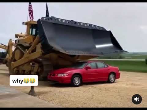 A huge tractor crushes a car