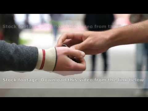 Male hands giving the keys to car to his friend. Handshake between two men outdoor.