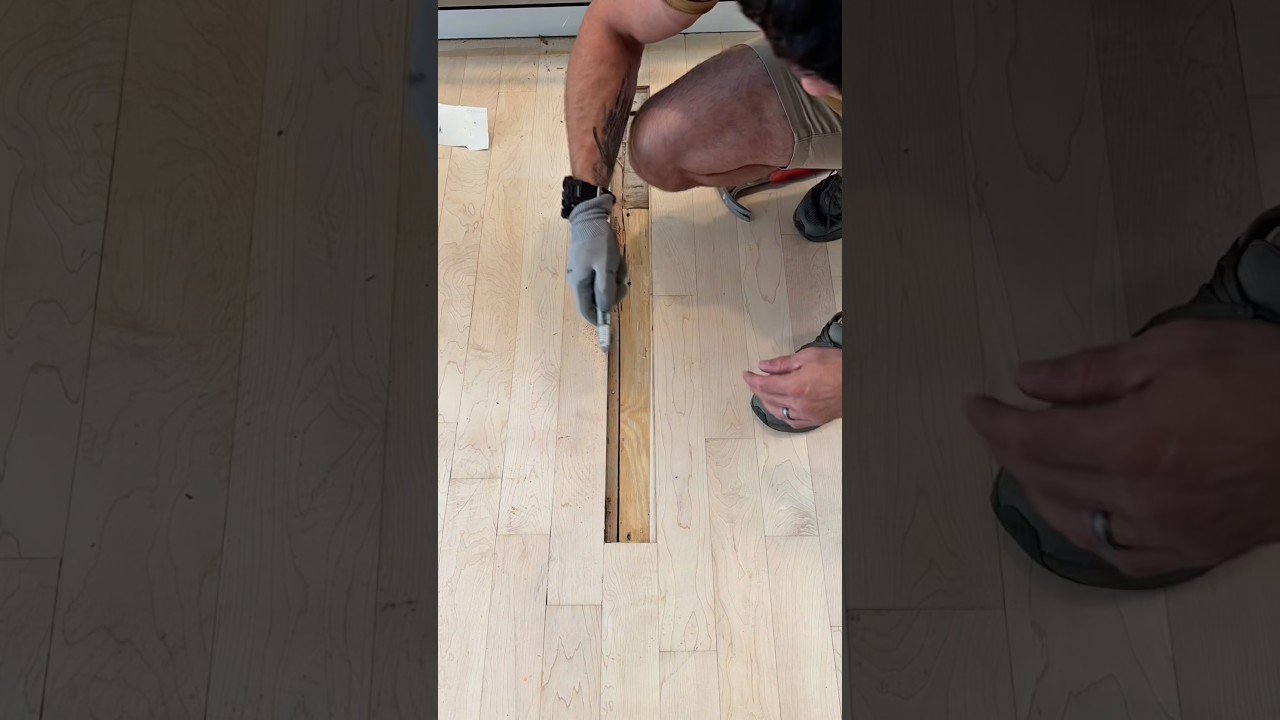Broken hardwood floor plank being professionally repaired