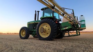 Spraying wheat field and working on John Deere 4455