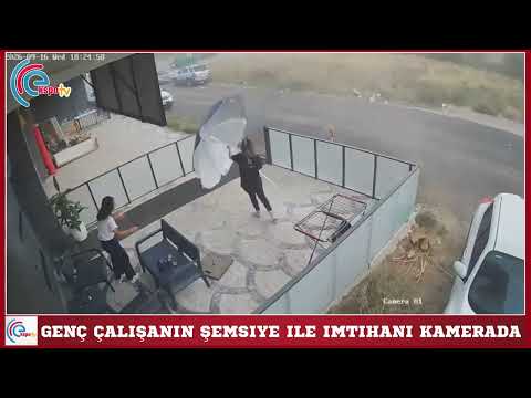 Genç çalışanın şemsiye ile imtihanı kamerada