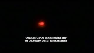 Group of orange UFOs in the night sky