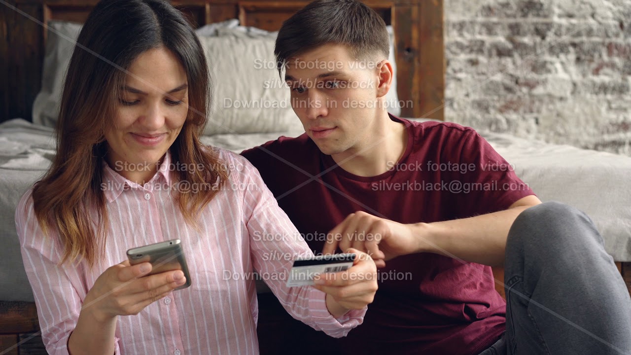 Pretty asian woman is shopping online paying with bank card using smartphone then hugging her
