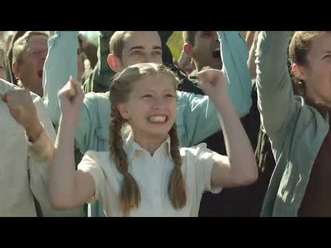Trailer still: spoof arena wide shot while EDM-inflected cue surges