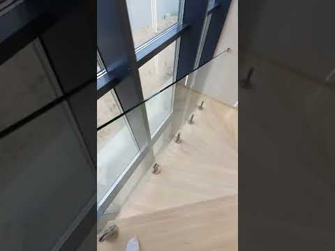 Стеклянное ограждение лестницы перед витражом.