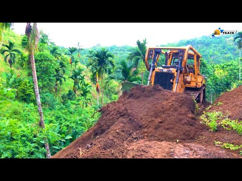 Extreme!! The D6R XL Bulldozer forms a new road by cutting a hillside at the edge of a ravine